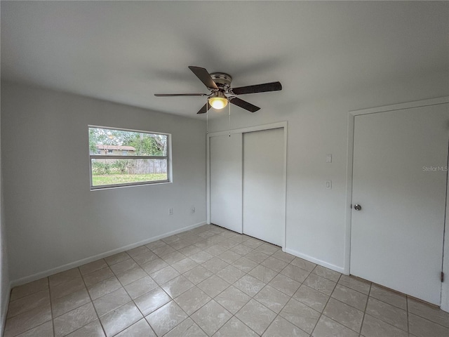 unfurnished bedroom featuring ceiling fan, light tile patterned floors, a closet, and baseboards