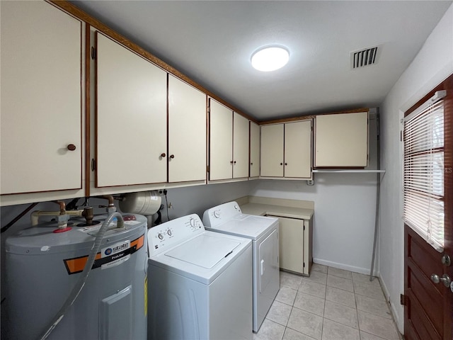 laundry room featuring light tile patterned flooring, washing machine and dryer, visible vents, water heater, and cabinet space