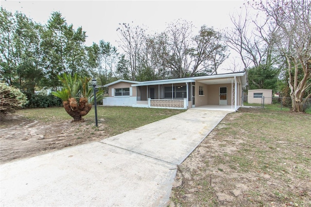 single story home with an attached carport, fence, concrete driveway, stucco siding, and a front lawn