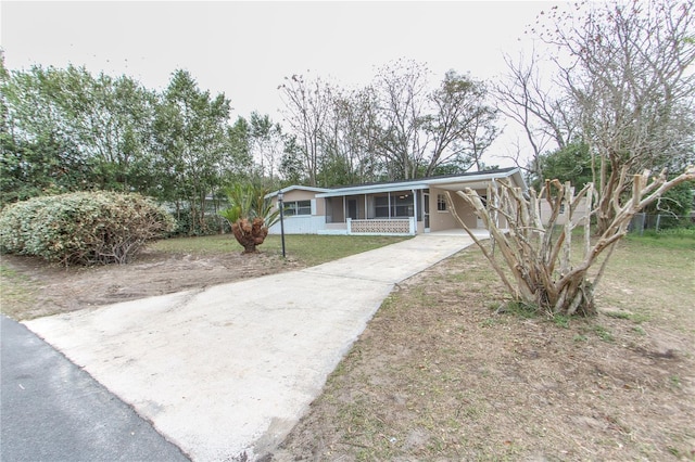 view of front facade with concrete driveway and an attached carport