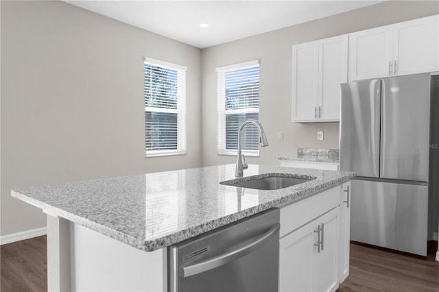 kitchen with stainless steel appliances, a sink, and white cabinets