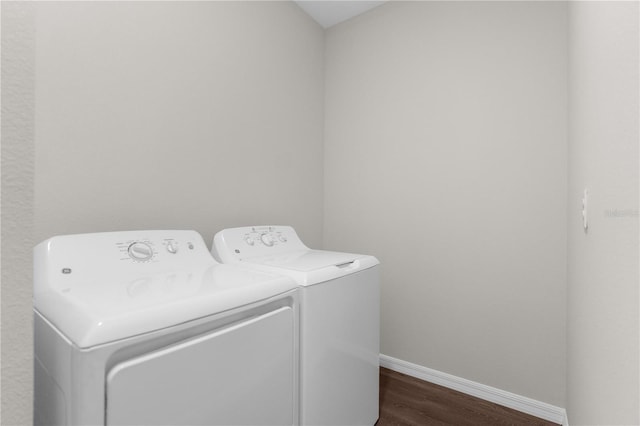 clothes washing area with laundry area, baseboards, dark wood-style floors, and separate washer and dryer