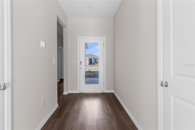 doorway featuring baseboards and dark wood finished floors