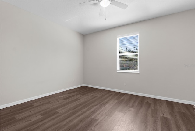 spare room featuring dark wood-style floors, baseboards, and a ceiling fan