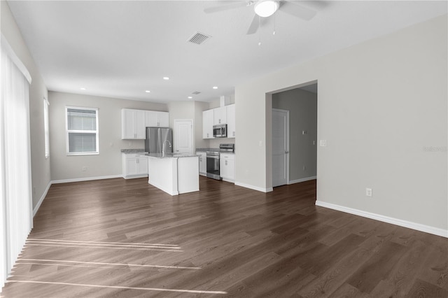 unfurnished living room with dark wood-style floors, recessed lighting, visible vents, ceiling fan, and baseboards