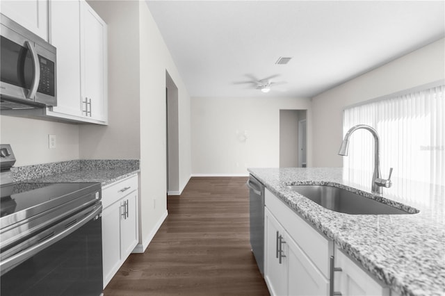 kitchen featuring light stone counters, a sink, visible vents, white cabinetry, and appliances with stainless steel finishes