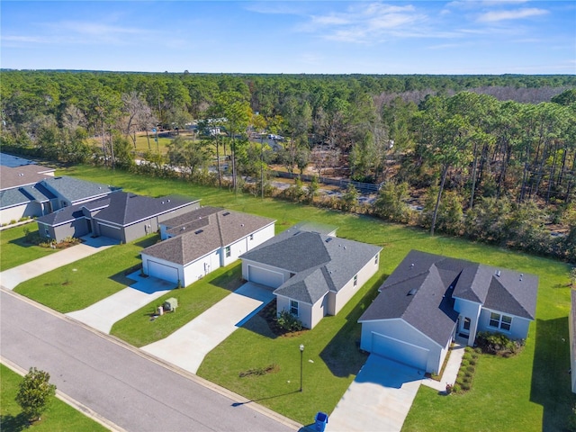 birds eye view of property featuring a residential view and a wooded view