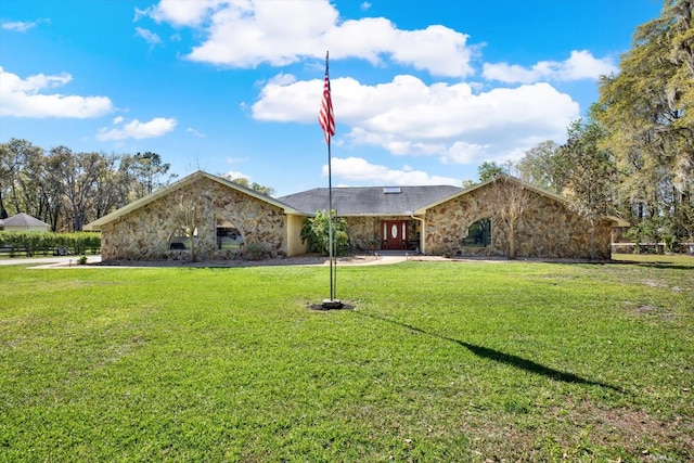 view of front of house with a front lawn and stone siding