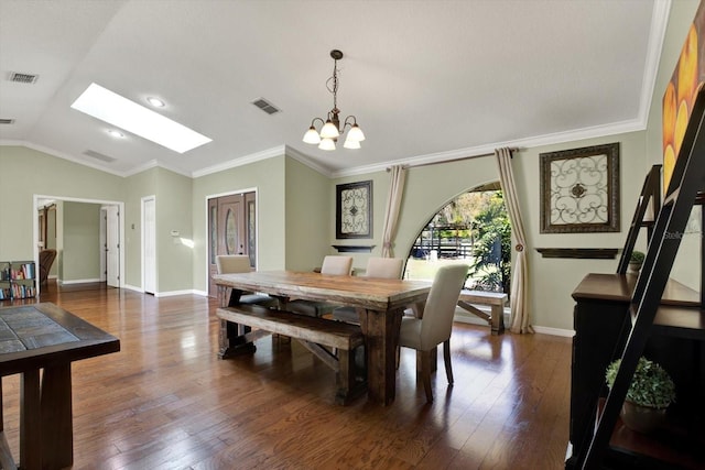 dining area with lofted ceiling with skylight, visible vents, dark wood-style flooring, and ornamental molding