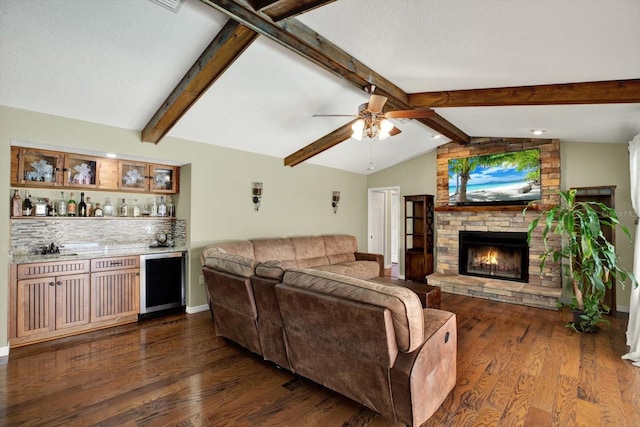 living area with vaulted ceiling with beams, dark wood-type flooring, beverage cooler, a dry bar, and a fireplace