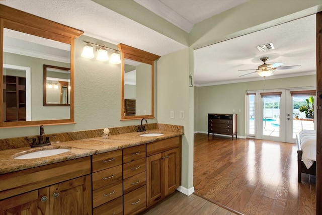 full bath featuring a sink, visible vents, wood finished floors, and crown molding