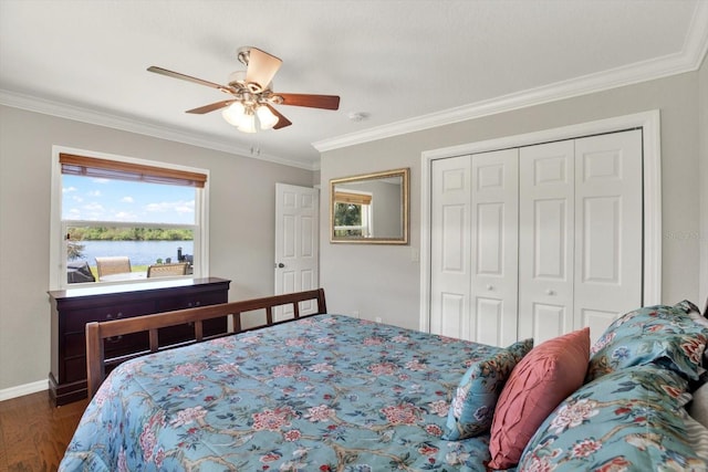 bedroom featuring a water view, a ceiling fan, wood finished floors, a closet, and crown molding