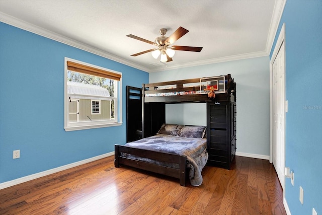 bedroom with ornamental molding, ceiling fan, baseboards, and wood finished floors