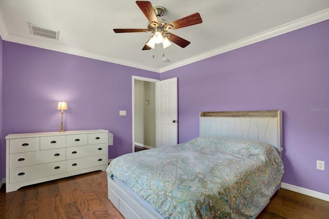 bedroom with crown molding, wood finished floors, visible vents, and baseboards