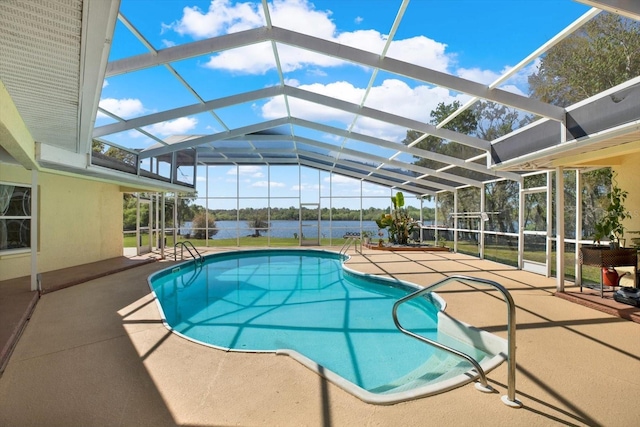 pool featuring glass enclosure, a water view, and a patio area