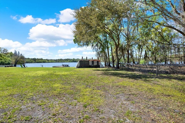 view of yard featuring fence and a water view