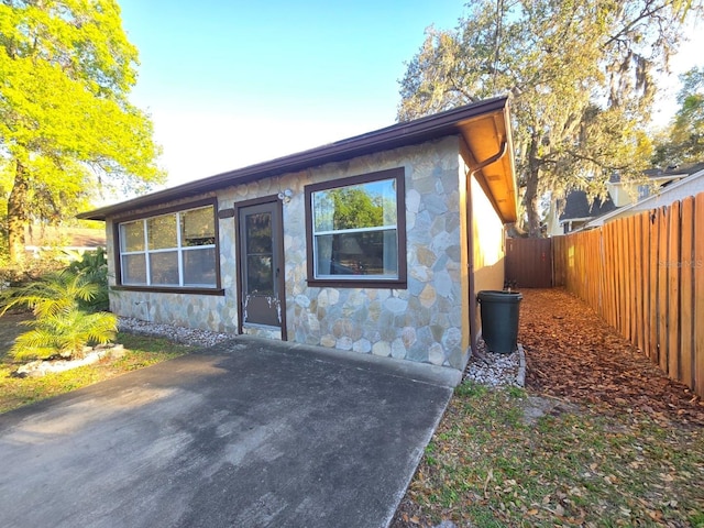 view of front facade with stone siding and a fenced backyard