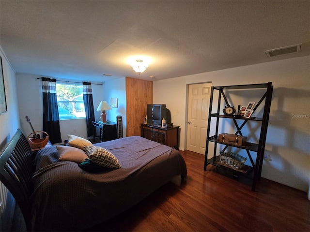 bedroom with visible vents and dark wood-style flooring