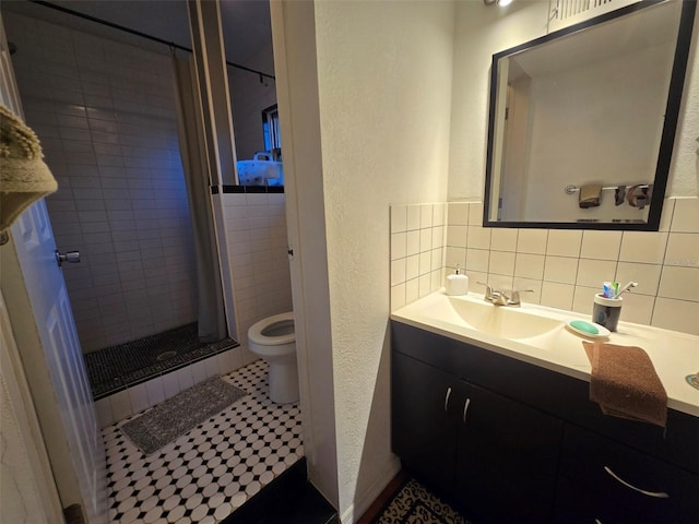 bathroom with toilet, backsplash, a shower stall, vanity, and a textured wall