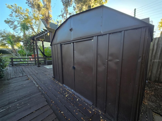 deck with a storage unit, an outdoor structure, and a pergola