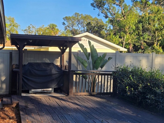 wooden deck with a grill and fence