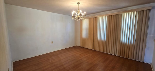 empty room with an inviting chandelier and wood finished floors