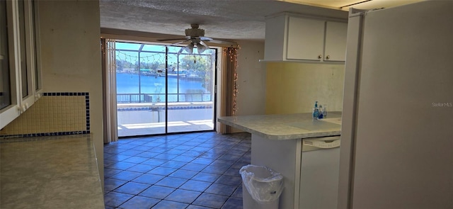 kitchen with light tile patterned floors, ceiling fan, light countertops, a textured ceiling, and dishwasher