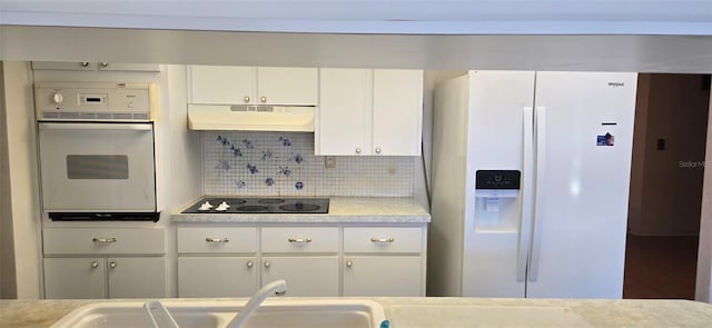 kitchen featuring tasteful backsplash, under cabinet range hood, light countertops, white appliances, and white cabinetry