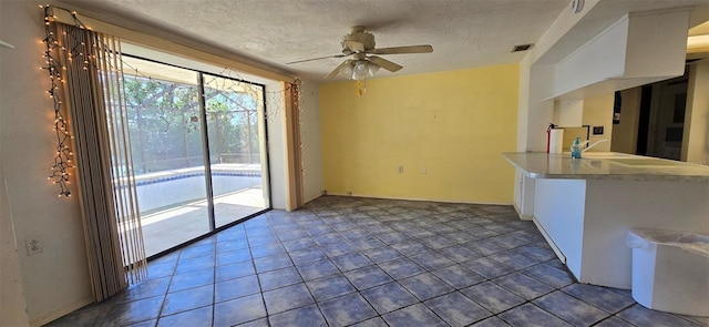 interior space with a sink, a textured ceiling, visible vents, and ceiling fan