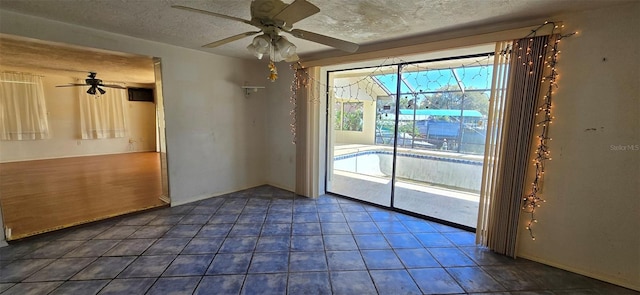 unfurnished dining area with tile patterned floors, a ceiling fan, and a textured ceiling