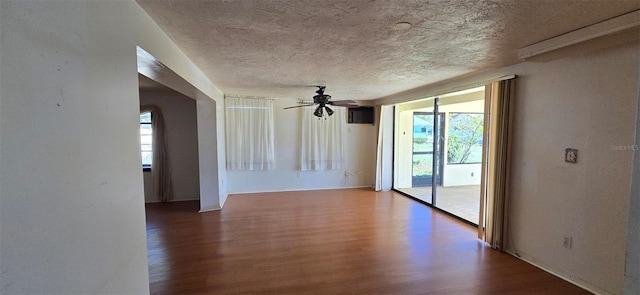 spare room with a textured ceiling, a ceiling fan, and wood finished floors