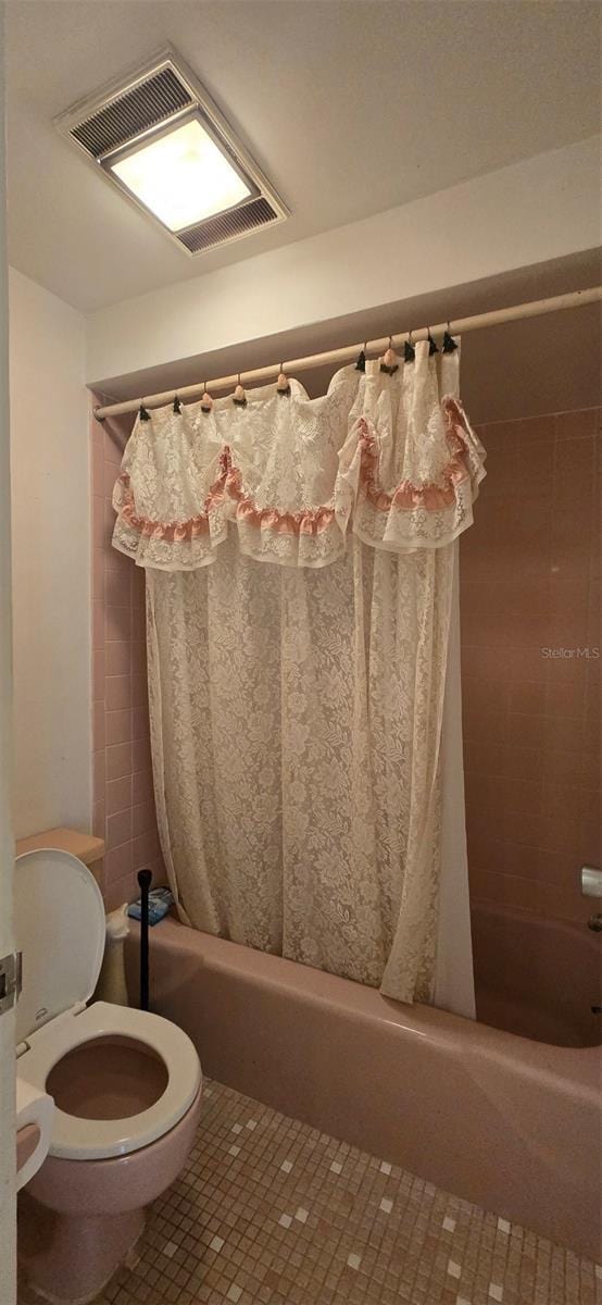 bathroom featuring visible vents, toilet, shower / bath combo, and tile patterned flooring