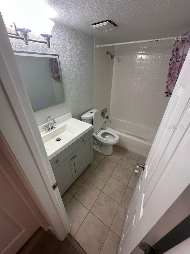 bathroom with a textured ceiling, a textured wall, vanity, tile patterned floors, and shower / tub combo with curtain