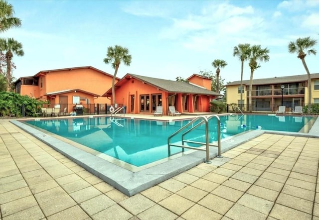 pool with a patio area and fence