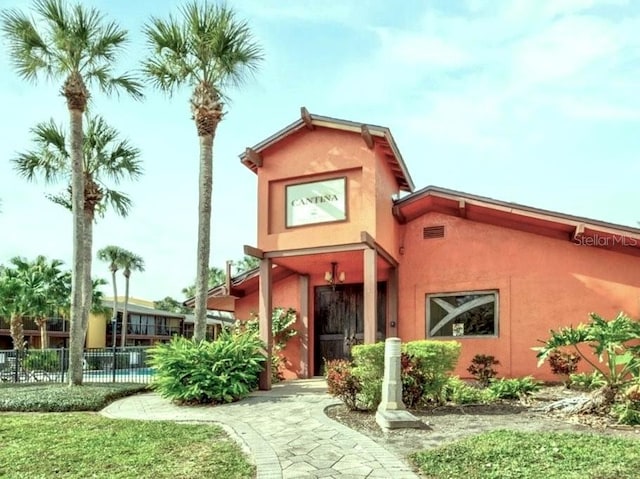 view of front facade featuring fence and stucco siding