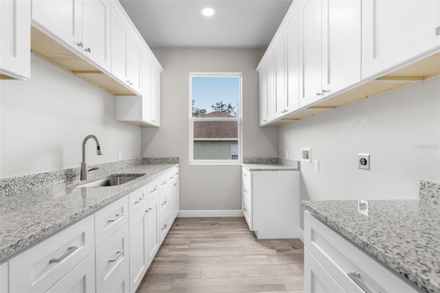 laundry area with washer hookup, light wood finished floors, cabinet space, a sink, and electric dryer hookup