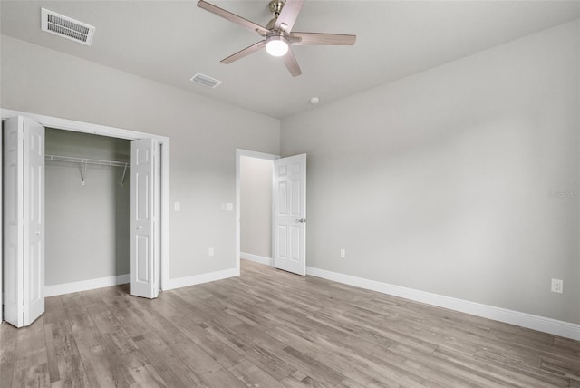 unfurnished bedroom with a closet, light wood-type flooring, visible vents, and baseboards