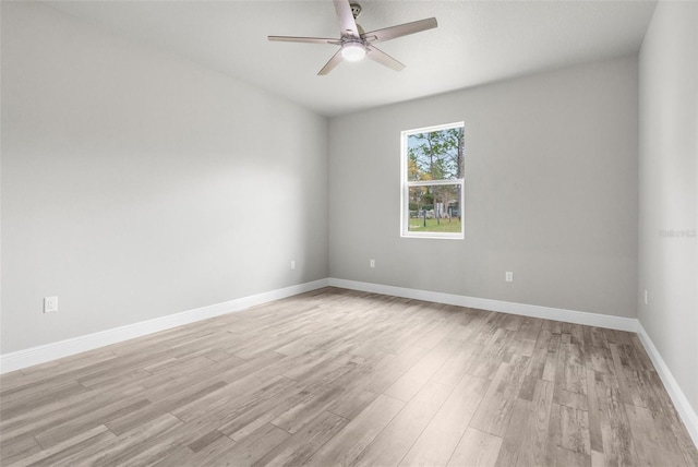 empty room featuring ceiling fan, light wood-type flooring, and baseboards