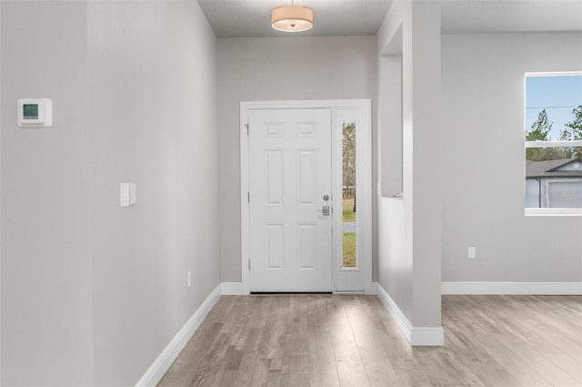 foyer entrance featuring light wood finished floors and baseboards