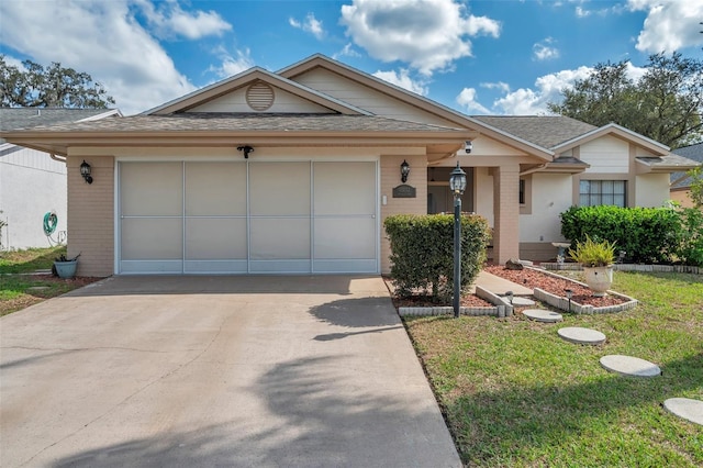 ranch-style home with driveway, brick siding, roof with shingles, and an attached garage