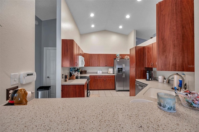 kitchen featuring light countertops, appliances with stainless steel finishes, a sink, high vaulted ceiling, and a peninsula