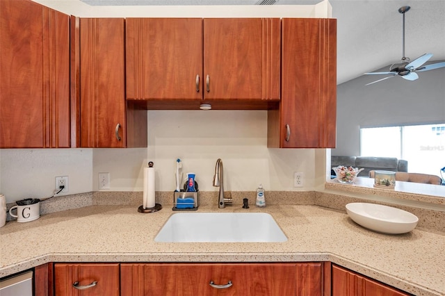 kitchen with a ceiling fan, brown cabinets, open floor plan, a sink, and stainless steel dishwasher