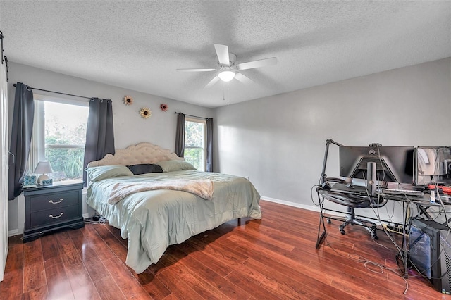 bedroom featuring dark wood finished floors, a textured ceiling, and baseboards