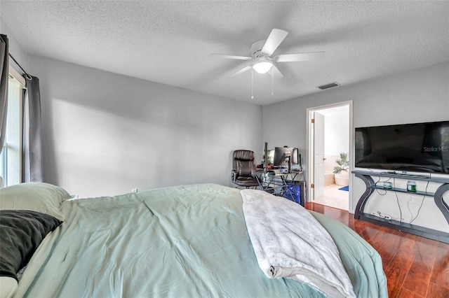 bedroom featuring visible vents, a ceiling fan, connected bathroom, wood finished floors, and a textured ceiling