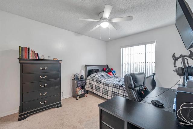 bedroom featuring light carpet, baseboards, a ceiling fan, and a textured ceiling