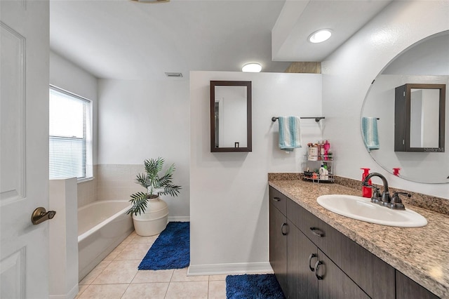 bathroom featuring tile patterned flooring, visible vents, vanity, baseboards, and a bath