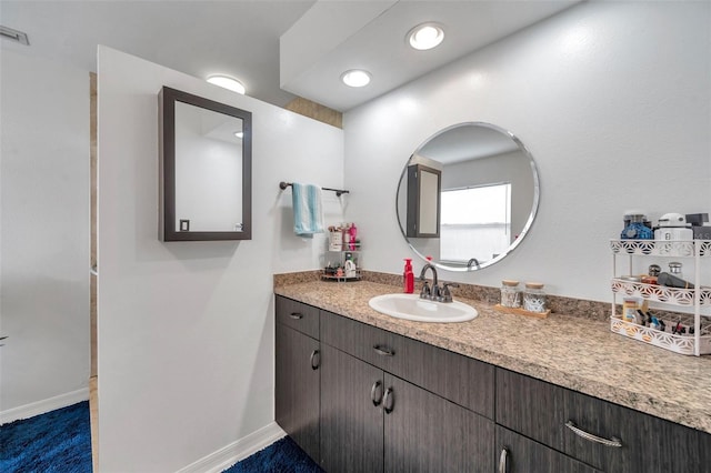 bathroom with recessed lighting, vanity, and baseboards