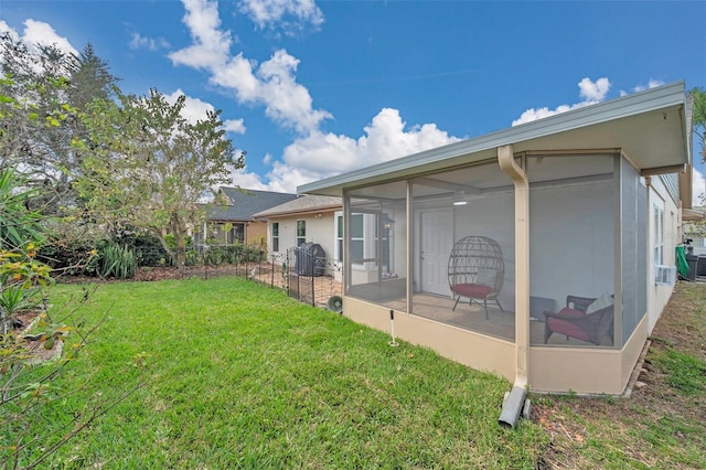 rear view of property with a sunroom, stucco siding, and a yard