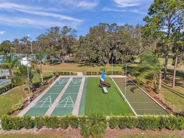 view of home's community with shuffleboard and a yard