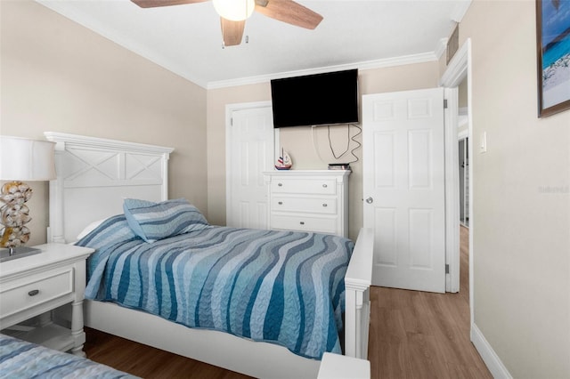 bedroom featuring light wood-style floors, ornamental molding, baseboards, and ceiling fan